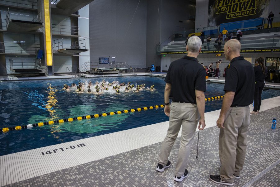 University of Iowa Men’s and Women’s Swimming and Diving Head Coach Marc Long talks with Iowa’s Head Diving Coach Todd Waikel while the men’s and women’s team celebrate after a win against the University of Minnesota at the CRWC on October 26, 2019. Iowa’s Men’s team won against Minnesota 156-144 while Iowa’s Women’s team lost 157-143.