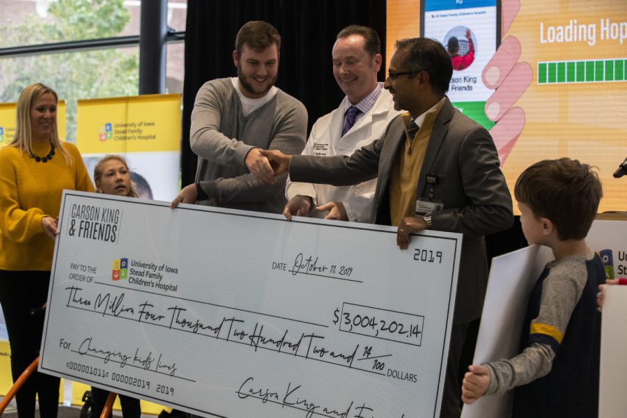 Carson King presents a check for $3,004,202.14 to UI Stead Family Children’s Hospital on Friday. King made headlines recently after a sign he held on ESPN’s game day resulted in raising millions of dollars  for a “beer fund.