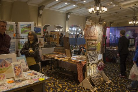 Customers shop through the art stalls during the Spring Art Expose in the IMU Main Lounge on Saturday Apr. 21, 2018. Put on by the UI Fine Arts Council, the Spring Art Expose celebrates local artists. 