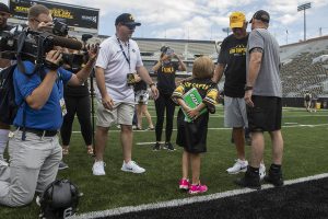 Kid Captain Gabby Yoder holds a large pack of gum to give Hawkeye Head Coach Kirk Ferentz at Kids Day at Kinnick on Saturday, August 10, 2019. Kids Day at Kinnick is an annual event for families to experience Iowas football stadium, while watching preseason practice and honoring this years Kid Captains. 