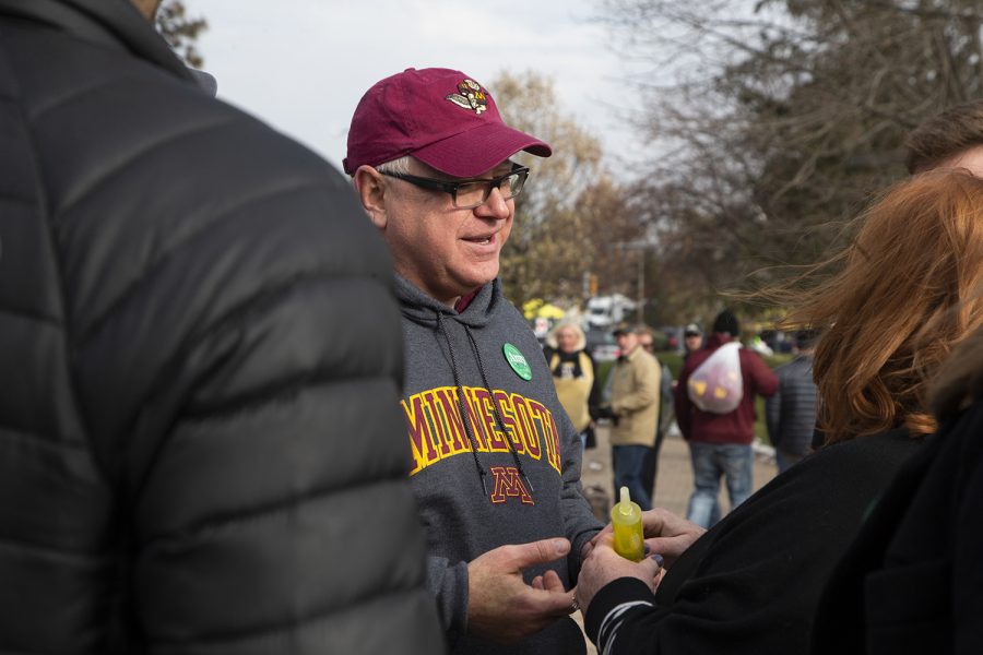 Kathleen McColaugh of Chicago offers Minnesota Governor Tim Walz a shot at a tailgate before the Iowa football game against No. 7-ranked Minnesota on Saturday, Nov. 16, 2019. Governor Walz, who campaigned on behalf of Sen. Amy Klobuchar, D-MINN., turned down the shot, “but they kept it,” McColaugh noted, joking that maybe he could enjoy it later. (Jenna Galligan/The Daily Iowan)