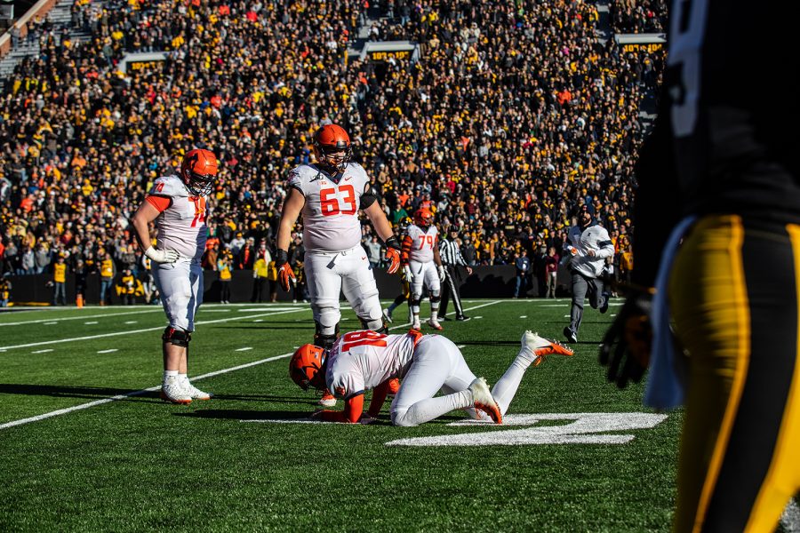 Iowa free safety Geno Stone walks by downed Illinois quarter back Brandon Peters during the game against Illinois on Saturday, November 23, 2019. The Hawkeyes defeated the Fighting Illini 19-10.