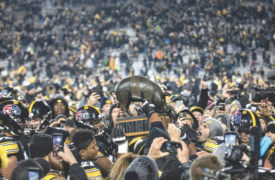 Iowa football players carry the Floyd of Rosedale trophy off the field after a football game between Iowa and Minnesota at Kinnick Stadium on Nov.16. The Hawkeyes defeated the Gophers, 23-19. 