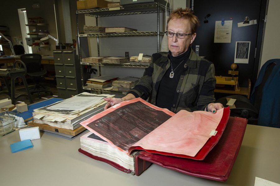 Former Head of the Preservation and Conservation Department Nancy Kraft examines a book of documents from the Linn County Registrar affected by the 2008 flood in the middle stage of the preservation process at the University of Iowa Main Library on November 7, 2019. Kraft oversaw the inclusion of new equipment to the preservation and conservation department, including a large digital device used to scan archival documents. 