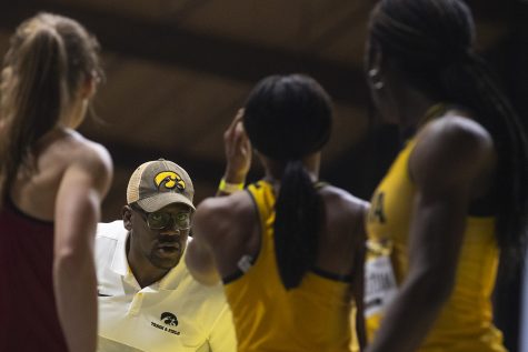 Associate Head Coach Clive Roberts coaches from the sidelines before the Women’s 4x400m relay during the Jimmy Grant Invitational at the University of Iowa Recreation Building on Saturday, Dec. 14, 2019.