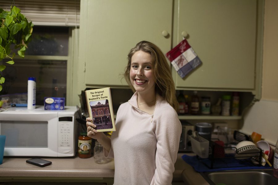 Daily Iowan arts reporter Addie Bushnell poses with a copy of The Original Recipes of Bushnell’s Turtle in her apartment on Dec. 10, 2019. 
