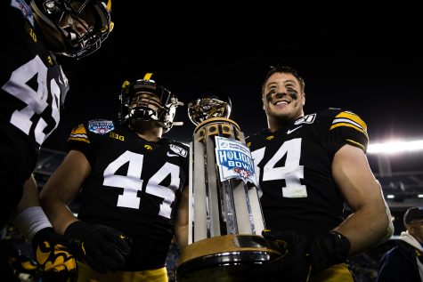Iowa linebackers Seth Benson (left) and Kristian Welch holds the trophy after the Holiday Bowl game between Iowa and USC at SDCCU Stadium on Friday, December 27, 2019. The Hawkeyes defeated the Trojans 49-24.