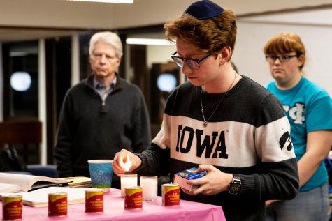 Caleb Marx lights a candle during a Holocaust Remembrance Day vigil at Iowa Hillel on Monday January 27, 2020. 