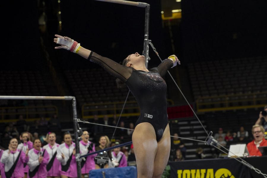Iowa’s all-around Carina Tolan sticks her landing after dismounting the bars during a gymnastics meet between Iowa and Michigan at Carver Hawkeye Arena on Friday, Feb. 14, 2020. The GymHawks were defeated by the Wolverines with a score, 195.975-196.800. Tolan earned a score of 9.800. 