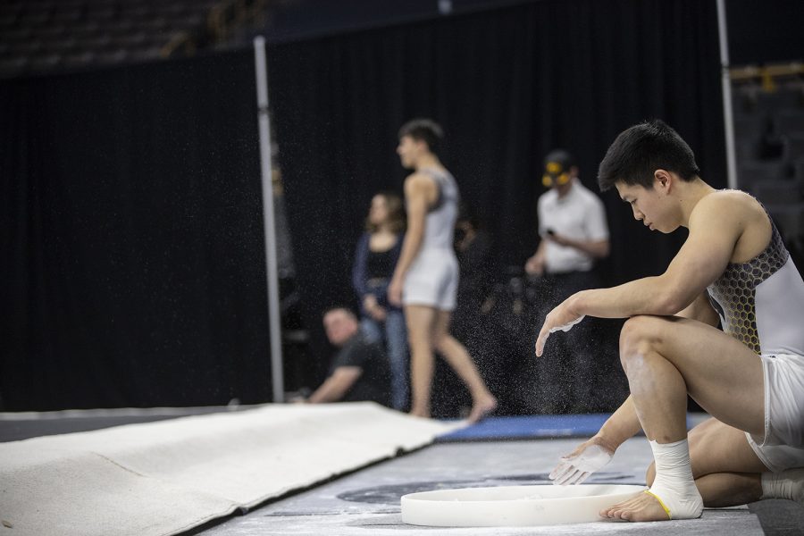 Iowa all-around Bennet Huang puts chalk on his hands during a Men’s gymnastics meet against The University of Minnesota and the University of Illinois at Chicago. The Hawkeyes won with a final team score of 400.00. Huang scored a total of 14.00 on his floor routine.