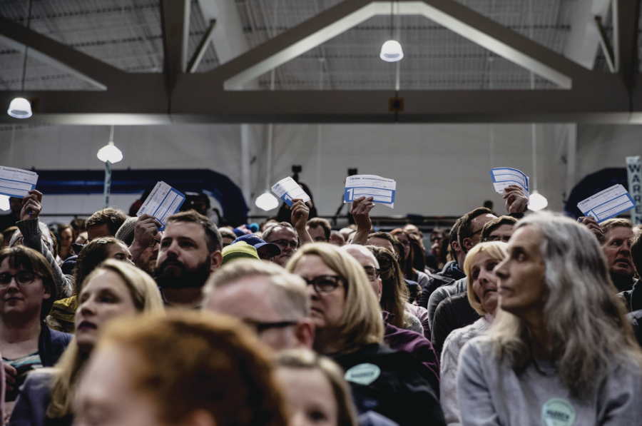 Supporters of Sen. Elizabeth Warren, D-Mass., hold up cards during the caucus at Des Moines Precinct 62 in the Knapp Center on Monday, February 3, 2020. The caucus head count reached 849 people, leaving 127 individuals needed for the candidate to be declared viable. Sen. Warren received 212 1st round total head count votes. 