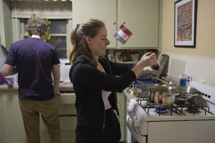 The Daily Iowan Arts reporter Addie Bushnell grinds pepper while following a corn chowder recipe from The Original Recipes of the Bushnell’s Turtle on Tuesday, Feb. 25, 2020.