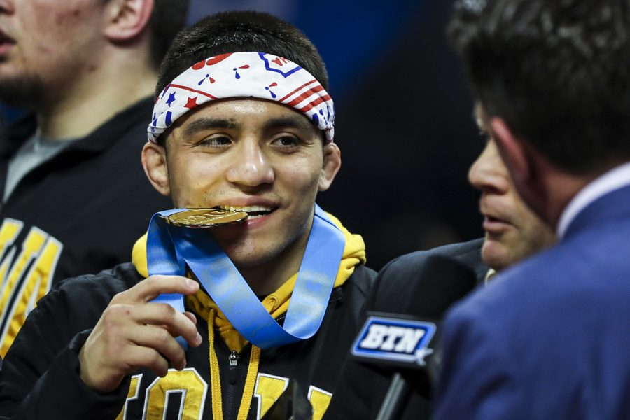 Iowas 149-pound Pat Lugo bites his gold medal during the final session of the Big Ten Wrestling Tournament in Piscataway, NJ, on Sunday, March 8, 2020. Lugo won by decision 2-1, securing the 149-pound championship, and Iowa won the team title with 157.5 points. 