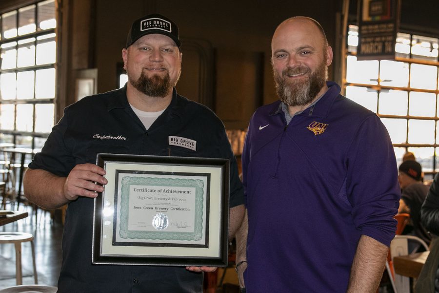 Iowa Waste Reduction Center Director Joe Bolick presents Iowa City Big Grove Director of Operations David Moore with the Certifcate of Achievement Platinum level on Friday March 13, 2020 at Big Grove Brewery.