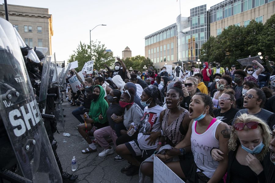 Protesters kneel in front of the police barricade during a protest outside of the Des Moines police station on Friday, May 29, 2020. An organized peaceful rally in honor of George Floyd and other victims of police brutality turned to violence following the event. Protesters threw water bottles at police while police sprayed tear gas and flares were thrown. 
