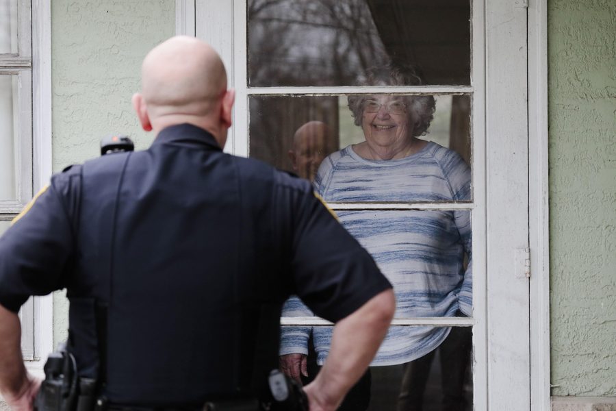 Sgt. Shawn Bean of the Perry Township Police Department chats with Jan Savage  while doing a senior-citizen check Friday. The department started its program because of the stay-at-home order brought on by the coronavirus pandemic. [Joshua A. Bickel/Dispatch]