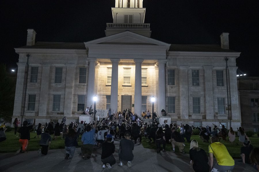 Protesters gather on the Pentacrest for a moment of silence during a protest in Iowa City on Monday, June 1, 2020. Protesters walk through downtown to the Johnson County Jail where they interacted peacefully with the police. Protesters then moved to the Iowa City Police Department where they smashed windows on a door. 