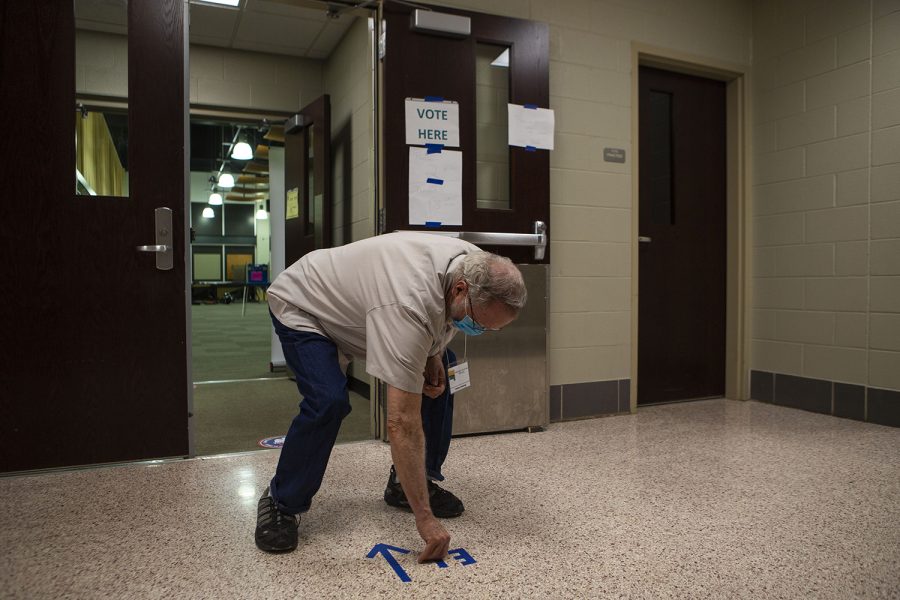 Jim Amlong peels up tape after polls closed on Tuesday, June 2 at Iowa City West High School.