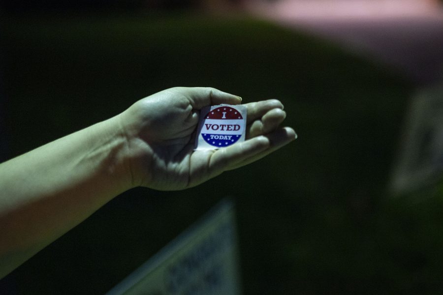 A voter poses for a photo with her sticker outside Iowa City West High School on Tuesday, June 2.