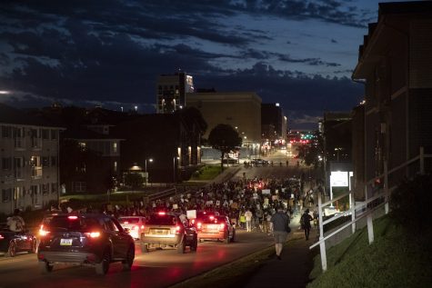 A crowd of protesters followed by a group of supporting vehicles travels west on Burlington Street towards downtown Iowa City during a march to support the Black Lives Matter movement and protest police brutality on Saturday, June 13. 