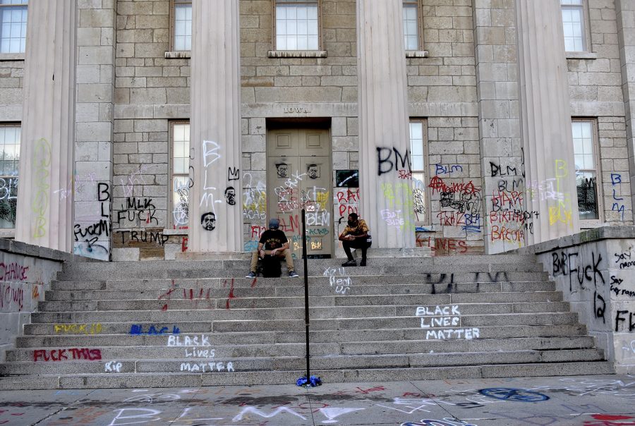 Protesters sit on the steps of the old Capitol while waiting for fellow protesters to gather during the Black Lives Matters march on Monday, June 23, 2020.