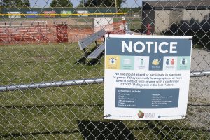 A sign for COVID-19 restrictions is posted outside the baseball field on Saturday, June 13 at West High School in Iowa City. 