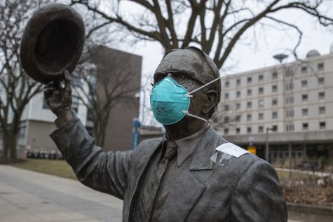 A mask sits on the Irving B. Weber statue in front of Van Allen on Thursday, March 12, 2020.