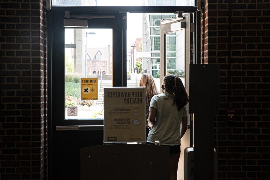 A pair of University of Iowa students leave the nearly deserted Chemistry Building on the first day of the new semester on Monday, August 24th, 2020. Despite the pandemic, campus remains open and some classes are still being held in person. (Tate Hildyard/The Daily Iowan)