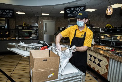 Burge Marketplace worker, Elijah Lyons prepares a takeout bag of dorm food on Monday, August 26th, 2020. Due to health and safety regulations as a means of preventing the spread of COVID-19, the dining hall process has been streamlined with an advanced registration process and a takeout meal process. 