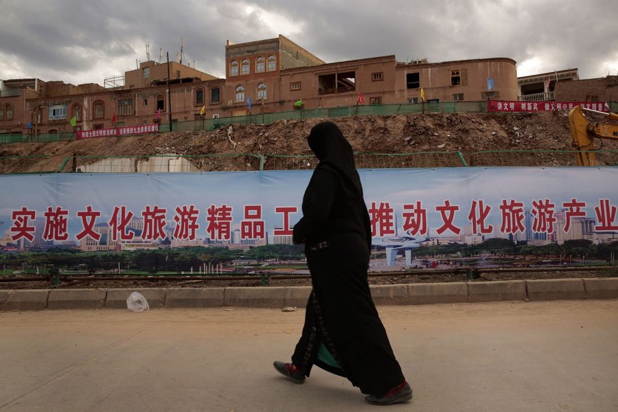 An Uyghur woman walks along an area of reconstruction in Kashgar, China. Many homes in the old urban district of Kashgar are being reconstructed, and many have been raised to build a new park.