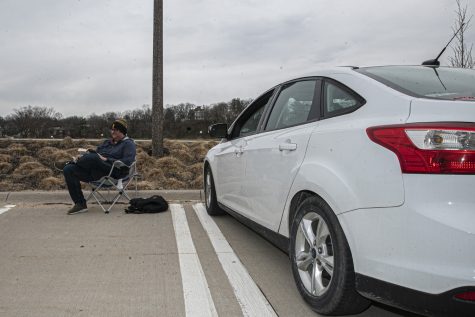 University of Iowa graduate student Philip Zaborowski does homework in the parking lot of Hancher Auditorium on Tuesday, April 2, 2020. As a result of COVID-19 creating a sudden influx of at-home work, the university attempted to aid in the congestion of internet traffic by installing free Wi-Fi in the Hancher parking lot.