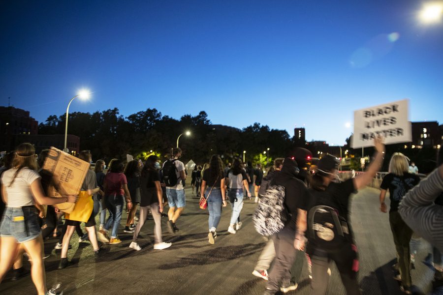 Protesters walk down Burlington Street during a Black Lives Matter protest organized by the Iowa Freedom Riders on Saturday, Aug. 29, 2020. This protest, a part of a four day protest streak, included a memorial for UI student Makeda Scott. Mourners left flowers and candles in front of the Old Capitol Building.