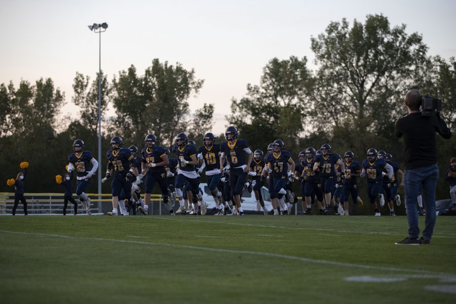 Reginas football team runs onto the field before a varsity football game with Wapello High School at Regina Catholic Education Center on Friday, Sept. 18, 2020 in Iowa City. The Regals defeated the Indians with a score 43-16.