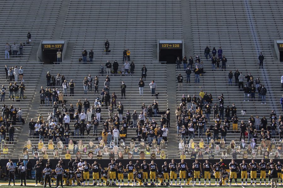Players kneel and stand for the national anthem before the Iowa v Northwestern football game at Kinnick Stadium on Saturday, Oct. 31, 2020. Head Coach Kirk Ferentz did not kneel for the anthem. Iowa is leading Northwestern with a score of 20-14 at the half. (Katie Goodale/The Daily Iowan)
