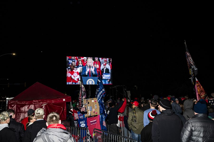 Members of the community watch President Donald Trump speak on a screen outside of a rally at the Knapp Center on Thursday, January 30, 2020. Hundreds of individuals including supporters, protestors, and members of the press were left outside after the event reached maximum capacity.