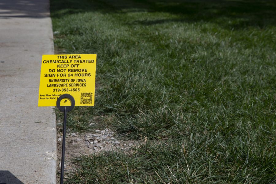 A sign warning students to stay off the grass sits on the Pentacrest on Sept. 4, 2019. Despite the warning about chemical treatment, some students continue to sit. 