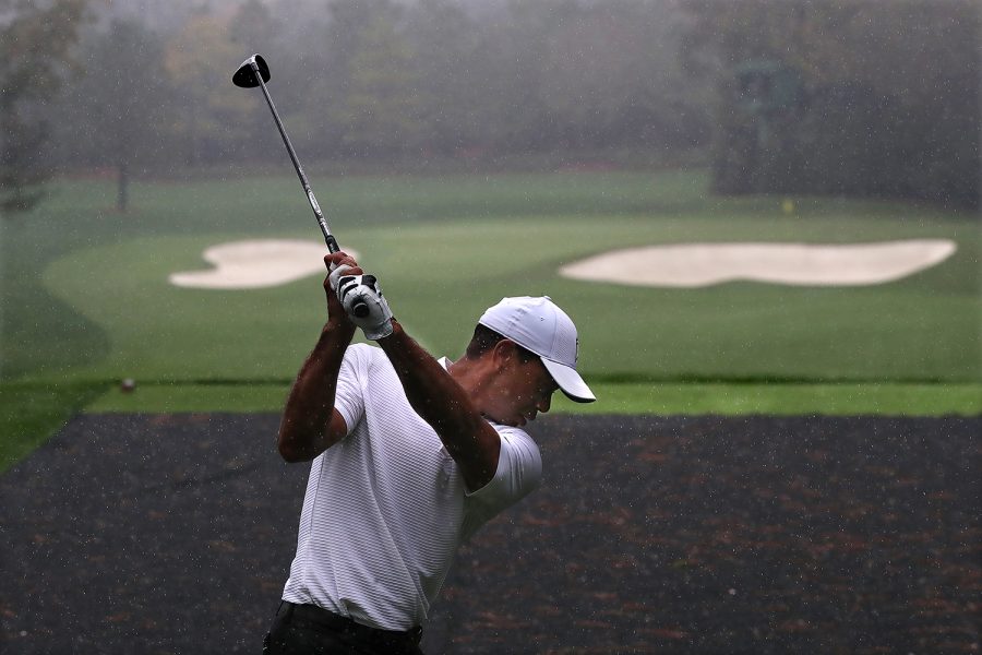 Defending champion Tiger Woods tees off in the rain on the par-3 4th hole during his practice round for the Masters at Augusta National Golf Club on Wednesday, Nov 11, 2020, in Augusta. 