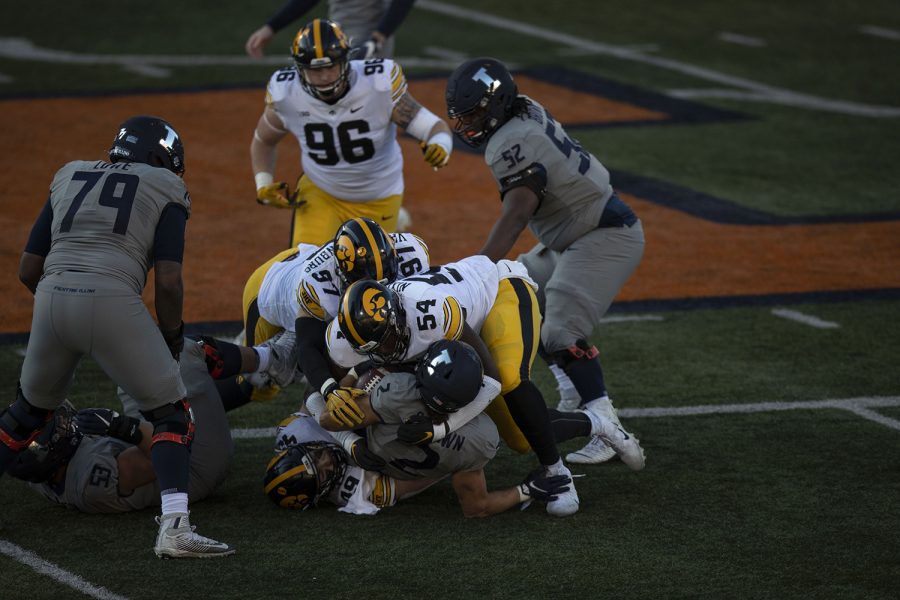 Illinois running back Chase Brown (2) is tackled by Iowa defenders during the first quarter of the Iowa v. Illinois football game at Memorial Stadium on Saturday Dec. 5, 2020. Iowa defeated Illinois with a final score of 35-21.