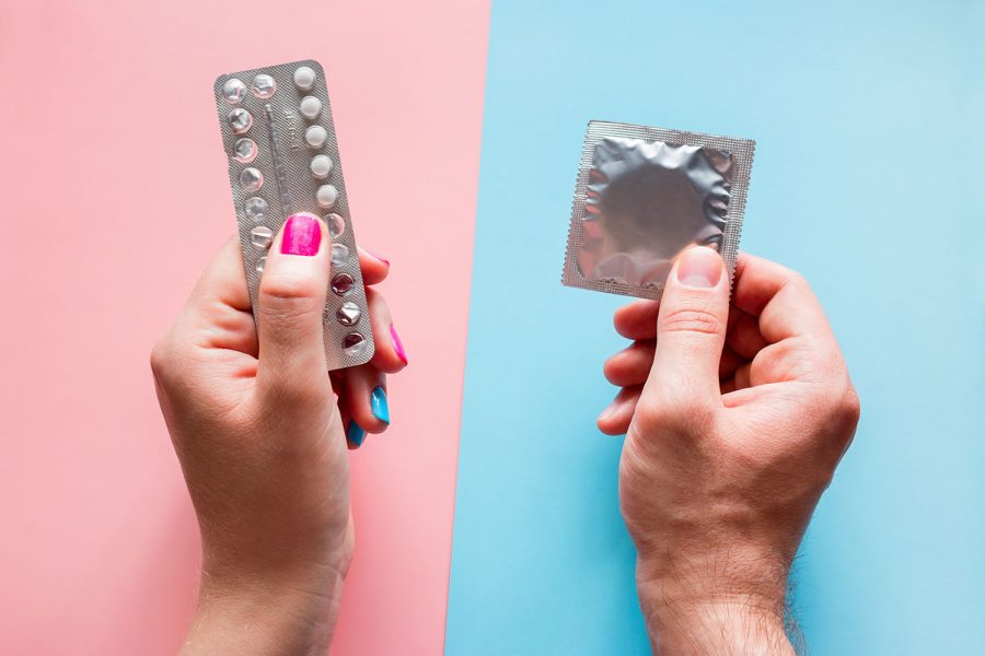Woman holds birth control pills, man holds condom.