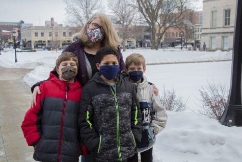 Julie Heidger and her children; Piers (left), Kaevion (middle), and Paul (right) pose for a portrait on Sunday, Jan. 24, 2021 on the Pentacrest at the University of Iowa. With no certainty when the pandemic will end, Heidger teachers her boys that their safe actions against COVID-19 can protect others.
