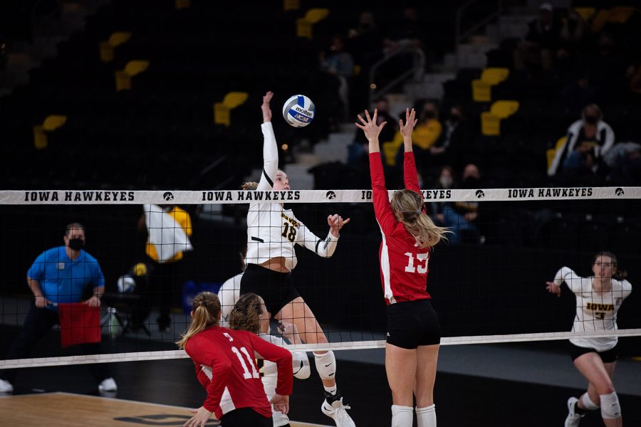 Middle Blocker Hannah Clayton attempts to spike one over Indiana’s Sophie Oliphant during a womens volleyball match between Iowa and Indiana at Xtream Arena on Friday, Feb. 5, 2021. 