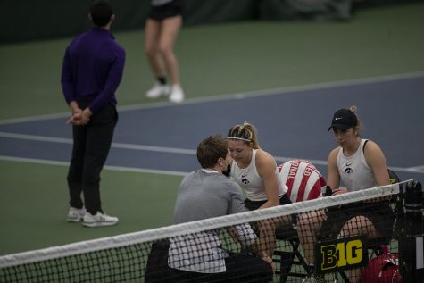 Doubles pair Alexa Noel (left) and Samantha Mannix (right) sit with a coach during the Iowa women’s tennis meet v. Northwestern in the Hawkeye Tennis and Recreation Complex on Sunday, Feb. 14, 2021. Northwestern defeated Iowa with a score of 6-1.