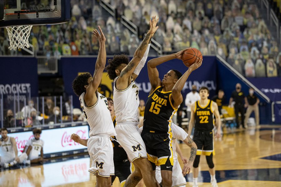Iowa Forward Keegan Murray (15) drives to the basket and tries to beat two Michigan defenders during the first half of a men’s basketball game at the Crisler Center in Ann Arbor, Michigan on Thursday, February 25, 2021. The Michigan Wolverines beat the Iowa Hawkeyes by a score of 79-57.