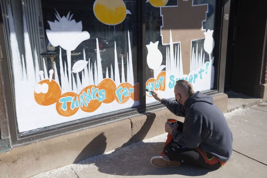 Painter Todd Woodburn of Art n Devours paints a mural on a shop window downtown Iowa City, on Tuesday Feb. 23, 2021. “A painting this ambitious takes about 6 hours to complete,” Woodburn said. 
