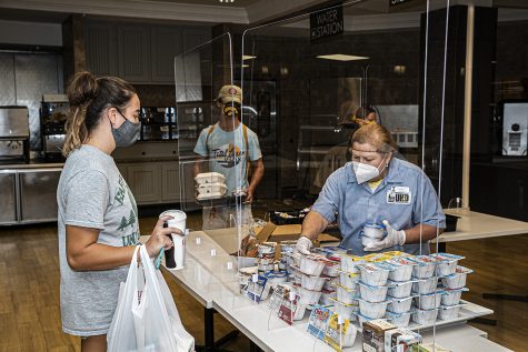 A Burge Marketplace worker serves a line of students on Monday, August 26th, 2020. Due to health and safety regulations as a means of preventing the spread of COVID-19, the dining hall process has been streamlined with an advanced registration process and a takeout meal process. 
