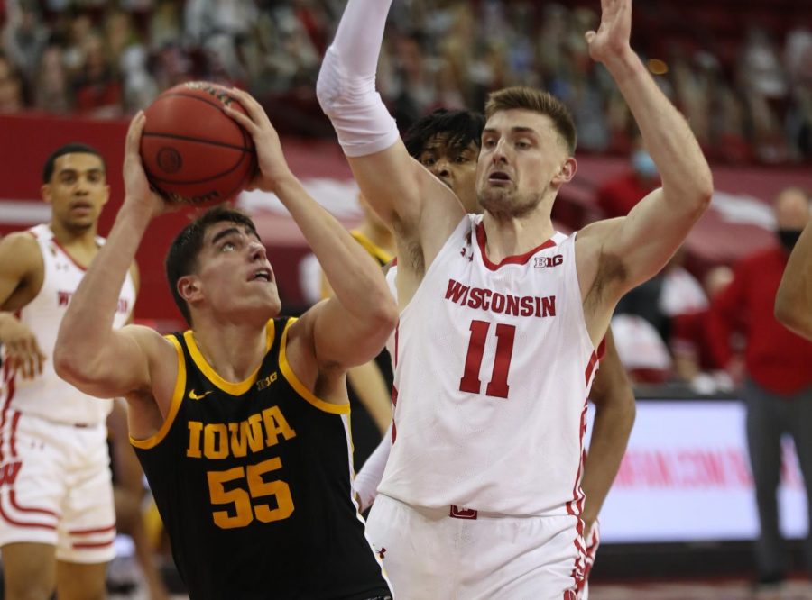 Feb 18, 2021; Madison, Wisconsin, USA; Iowa Hawkeyes center Luka Garza (55) looks to shoot as Wisconsin Badgers forward Micah Potter (11) defends during the second half at the Kohl Center. Mandatory Credit: Mary Langenfeld-USA TODAY Sports