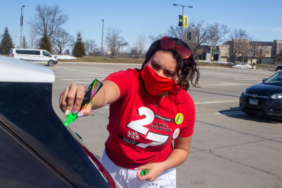 University of Iowa senior, Juliana DeSouza, decorates her car before the start of the University of Iowa Dance Marathon Parade on Saturday, Feb. 27 behind Kinnick Stadium in lot 43. Most of the other Dance Marathon events were held virtually this year due to COVID.