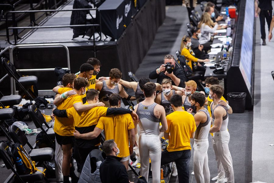 The Iowa men’s gymnastics team huddles on Saturday, Feb. 20, 2021 during the Iowa vs. Penn State men’s gymnastics meet at Carver-Hawkeye Arena. Iowa defeated Penn State 398.850-393.550. Men’s gymnastics has not been reinstated like the women’s swimming and diving team was earlier in February, so this is will be their final season.