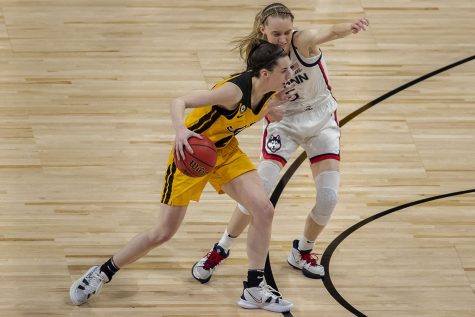 Iowa guard Caitlin Clark blocks UConn guard Paige Bueckers during the Sweet Sixteen NCAA women's basketball championship against UConn on Saturday, March 27, 2021 at the Alamodome in San Antonio, Texas. The Hawkeyes were defeated by the Huskies, 92-72. Clark and Bueckers played together on the U-17 and U-19 Team USA basketball team in high school, and both say they are still close friends.