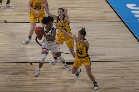 Iowa guards Caitlin Clark and Gabbie Marshall block UConn guard Christyn Williams during first quarter of the Sweet Sixteen NCAA womens basketball championship against No. 1 UConn on Saturday, March 27, 2021 at the Alamodome in San Antonio, Texas. The Hawkeyes are trailing behind the Huskies, 49-35 at halftime.